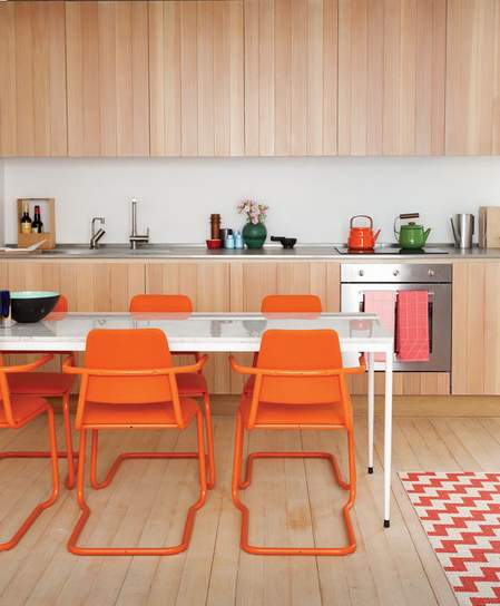kuhinja u prirodnoj boji drveta i narandžaste stolice