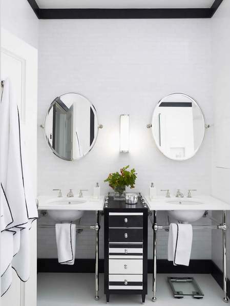 ovalna ogledala u crno belom kupatilu