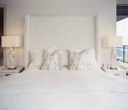bračni krevet sa visokim uzglavljem u beloj spavaćoj sobi